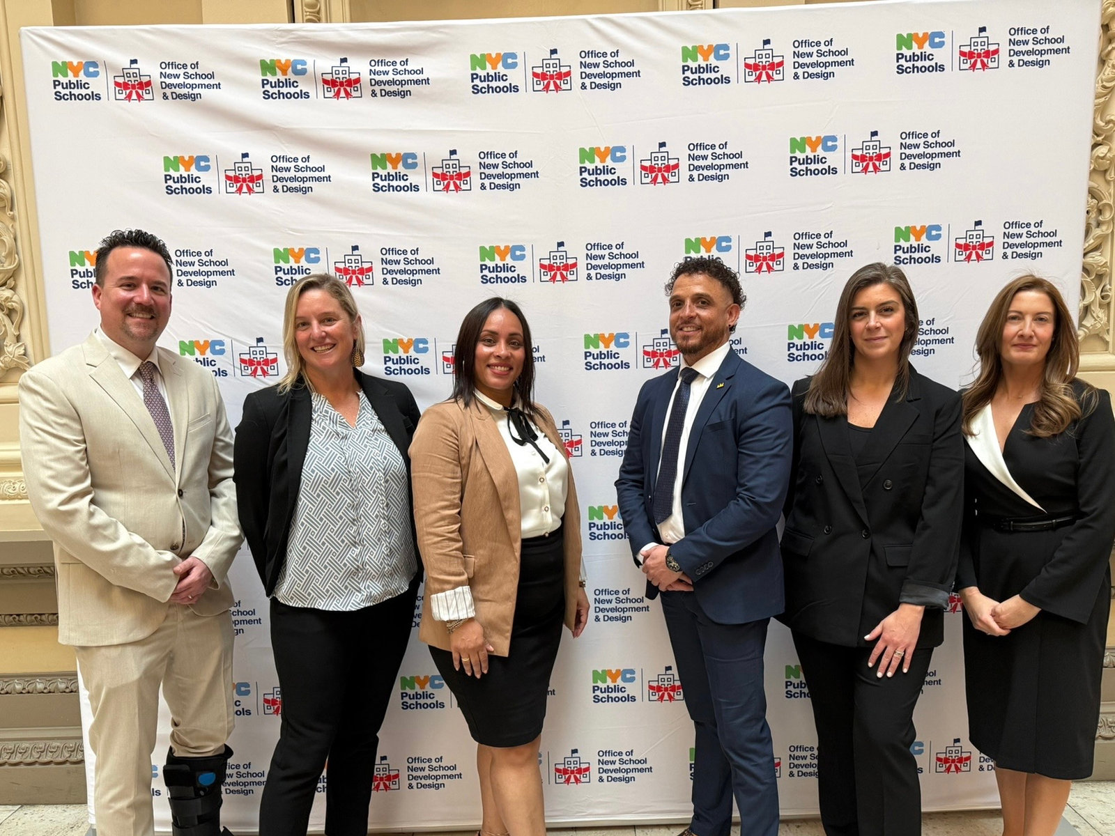 West Q’s founding team with NYC Public Schools staff in front of a press backdrop