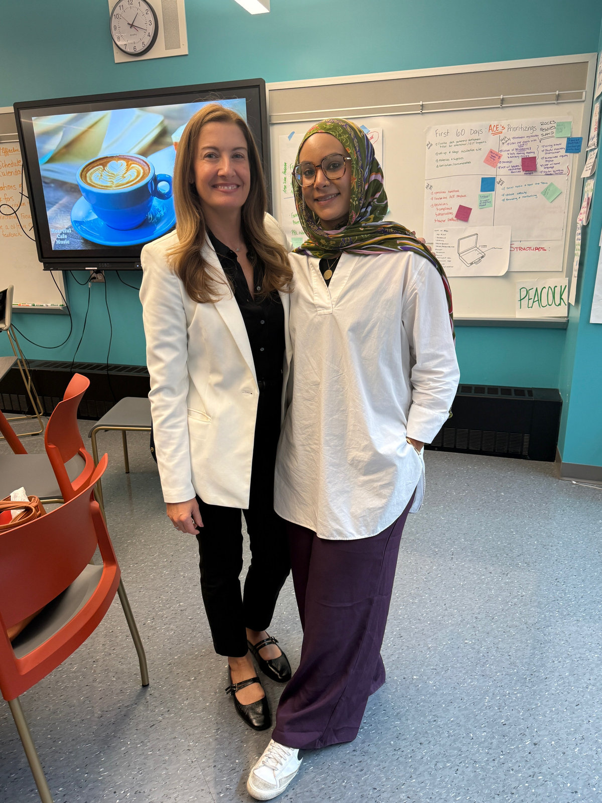 Two educators standing together in a bright classroom